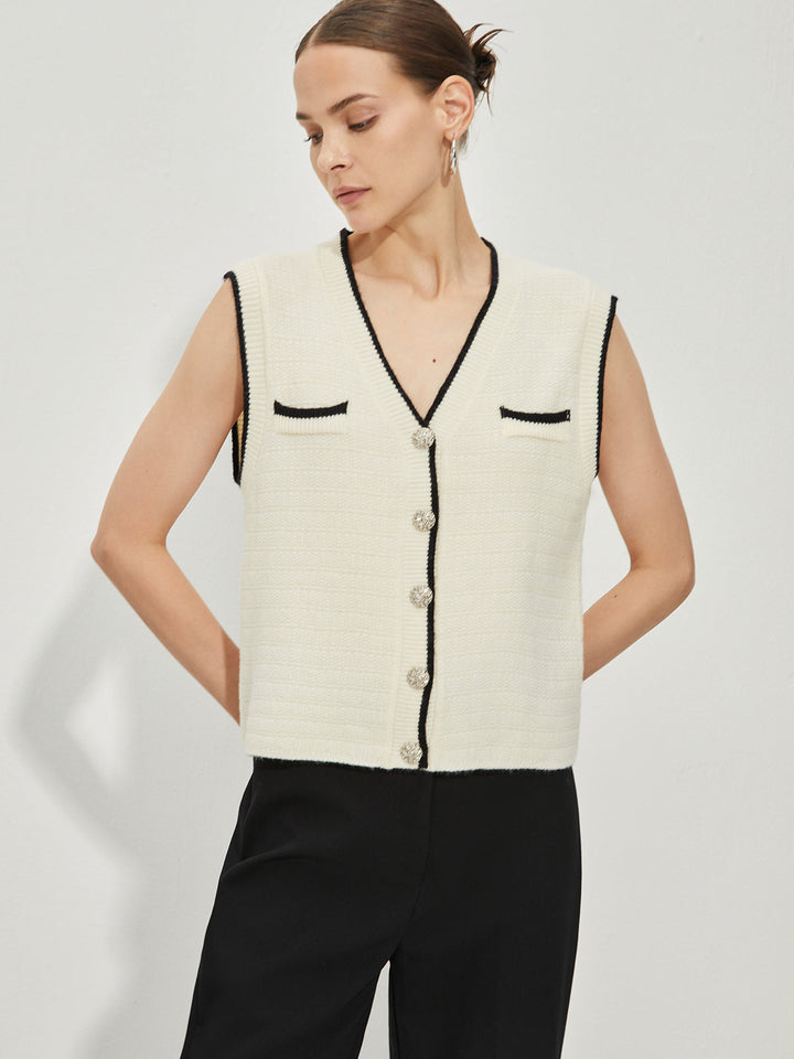 Sweater vest with contrasting metal button